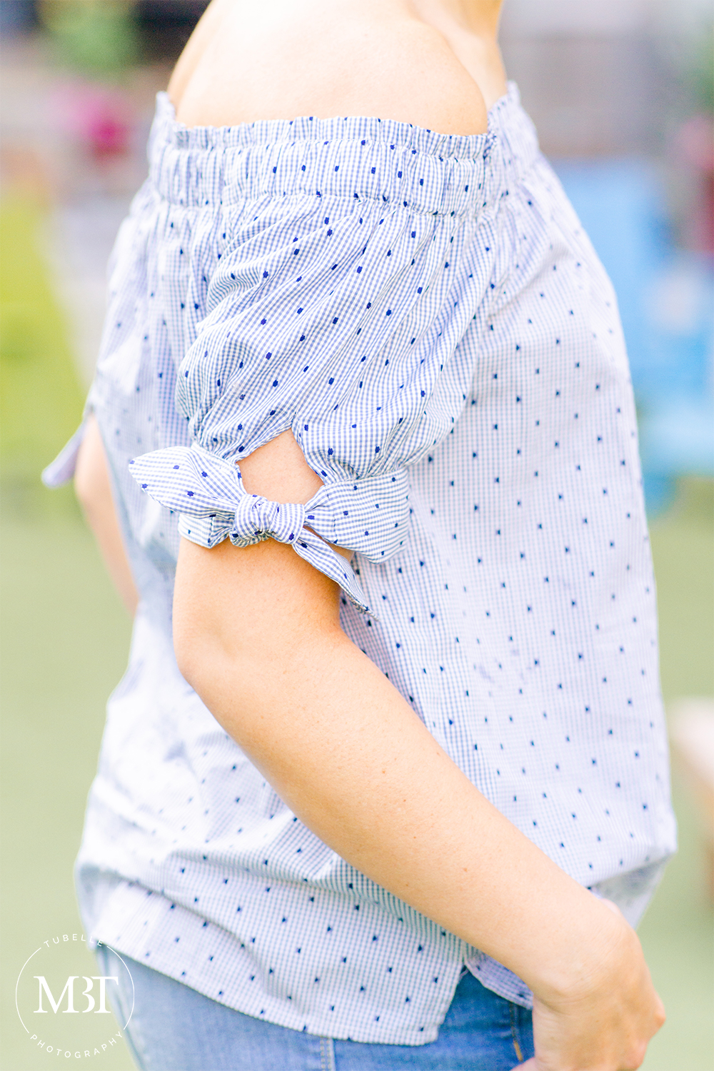 closeup of a blue striped off the shoulder top with bow on the sleeves, fashion session taken in Arlington, Virginia by a lifestyle photographer in Northern Virginia