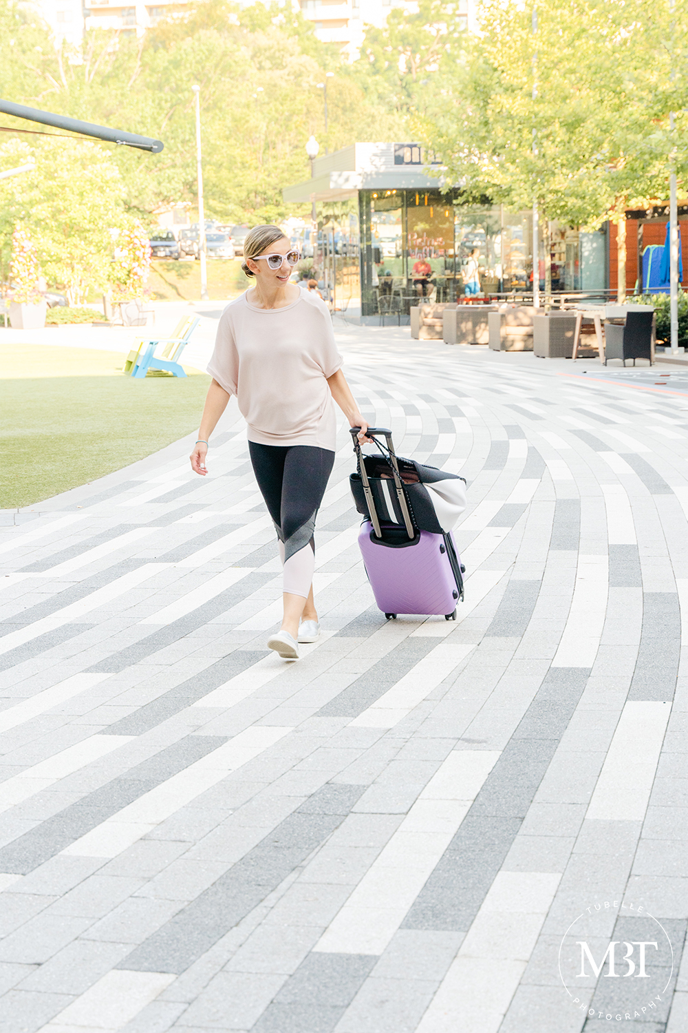 woman wearing workout clothes with tote bag and purple luggage, fashion session taken in Arlington, Virginia by a lifestyle photographer in Virginia