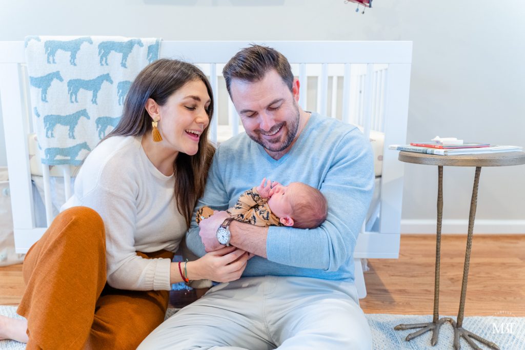 parents admiring baby during their in home newborn session in NoVa by a DMV newborn photographer