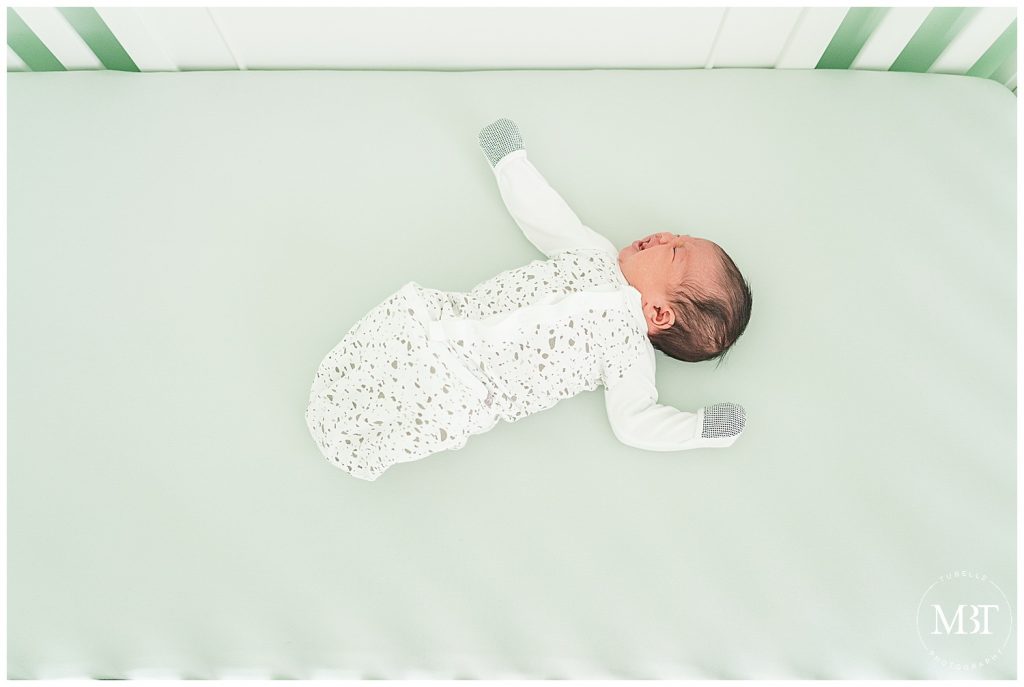baby girl in her crib during their at home newborn photos in Gainesville, Virginia, taken by TuBelle Photography, a NoVa newborn photographer