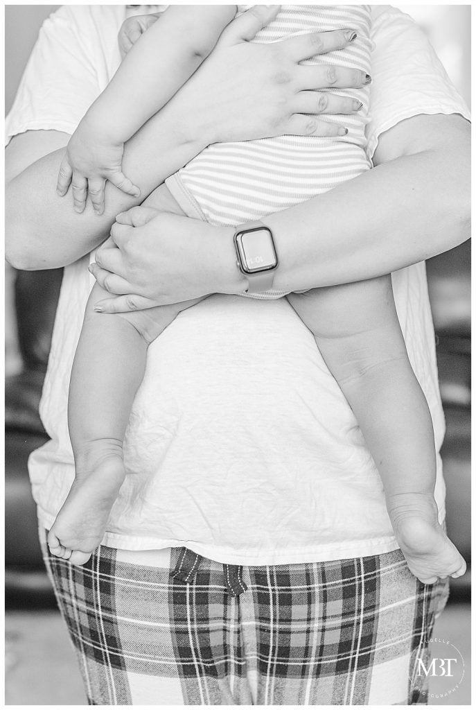 mom carrying baby boy, while baby is holding on to mommy