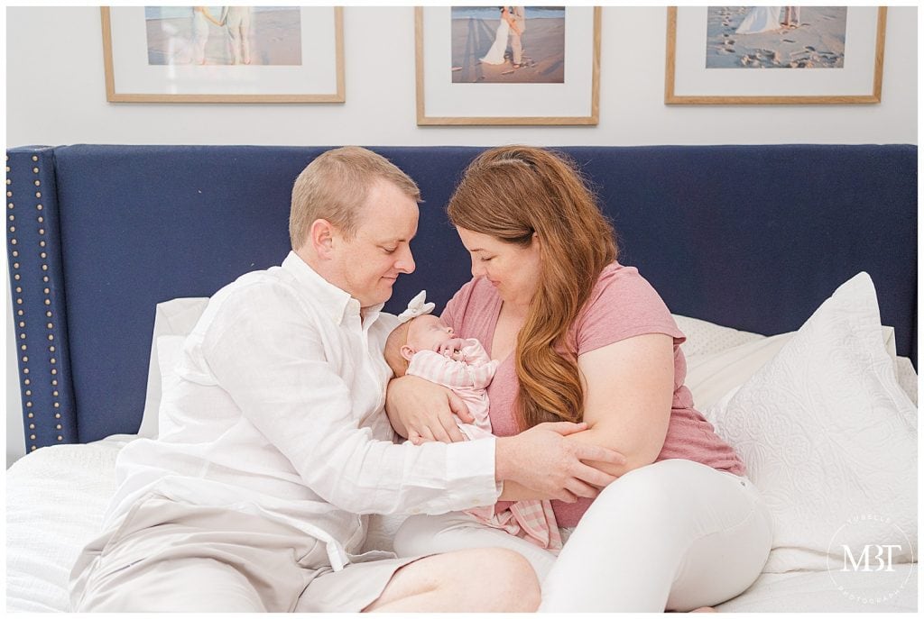 in-home newborn portraits in nova taken by Northern Virginia newborn photographer TuBelle Photography of mom and dad smiling down at baby